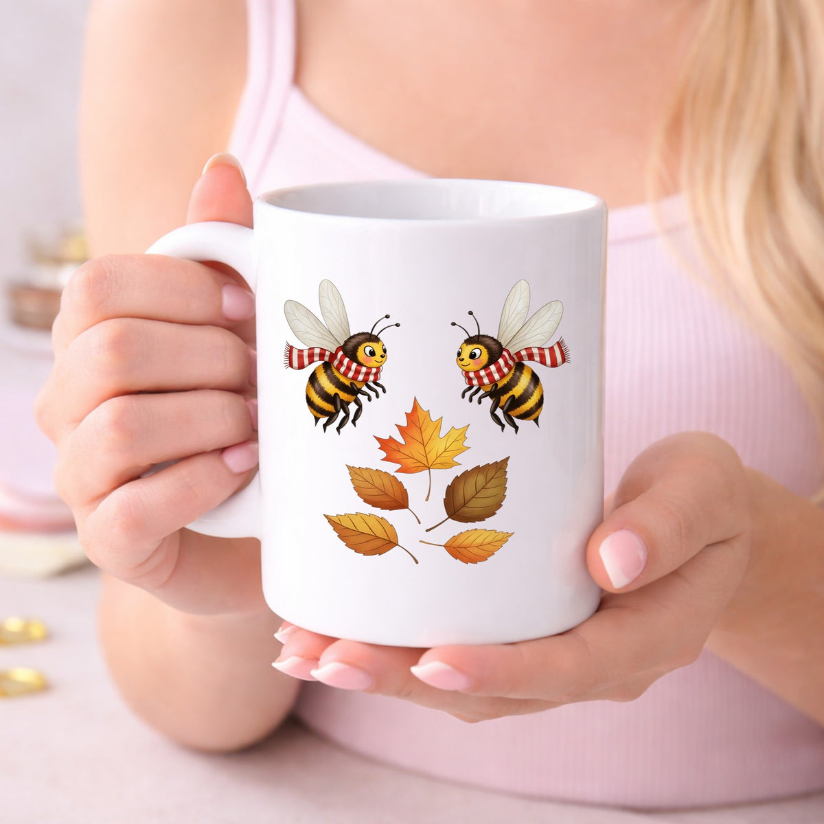 Two Bees With Autumn Leaves UV DTF sticker applied to a white coffee mug held in both hands