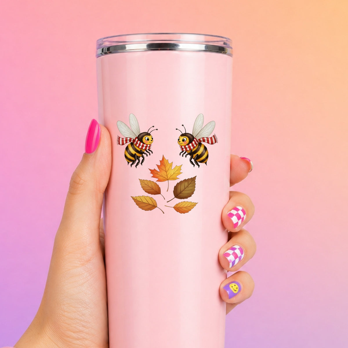 Two Bees With Autumn Leaves UV DTF sticker applied to a tall pink tumbler on a pink and orange background