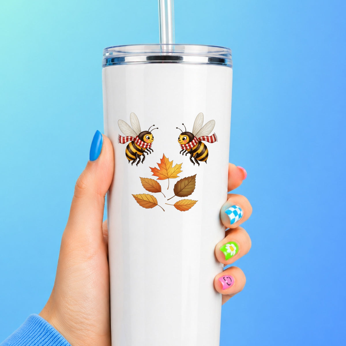 Two Bees With Autumn Leaves UV DTF sticker applied to a white straw tumbler on a blue background