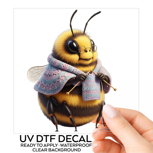 Bee Knitting In Shawl UV DTF sticker on its backing card, held in hand