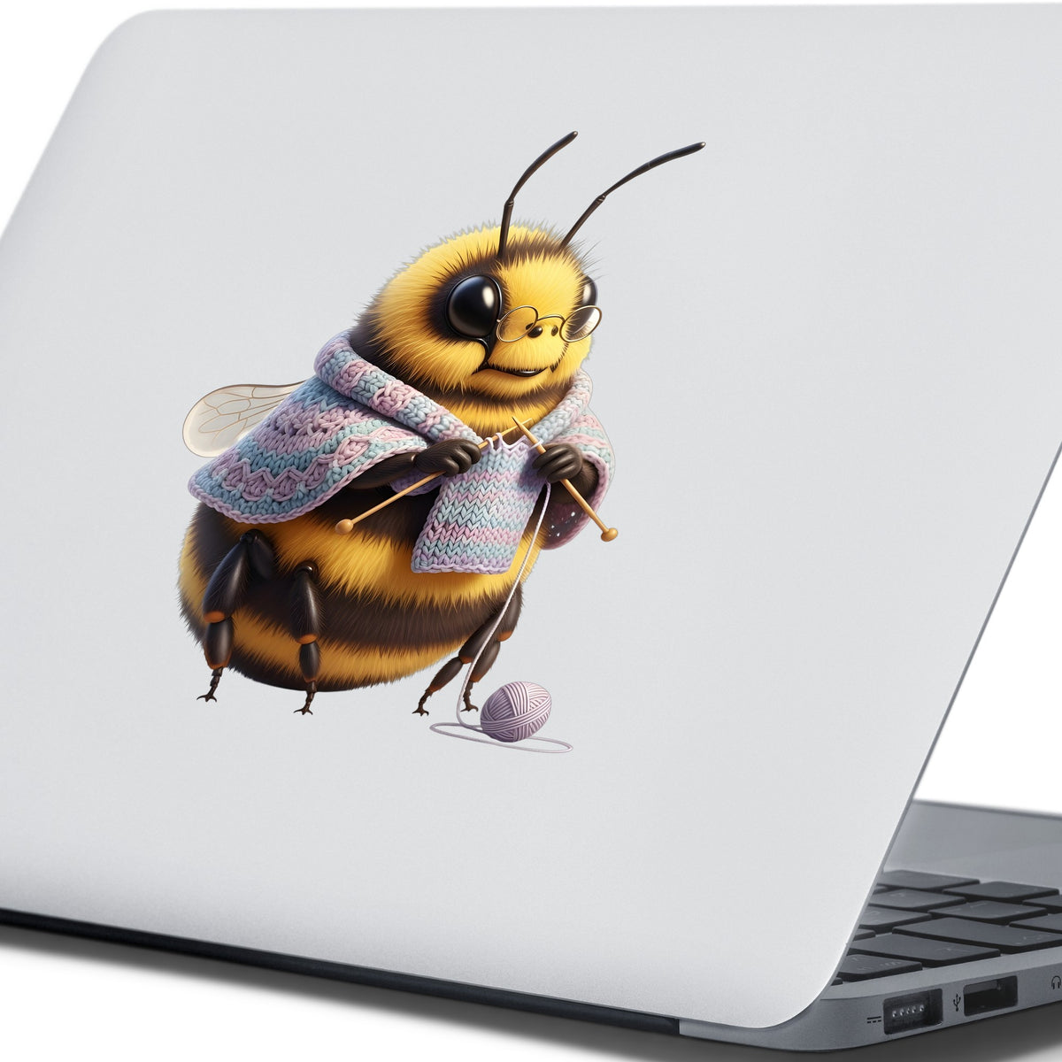 Bee Knitting In Shawl UV DTF sticker applied to the lid of a silver laptop