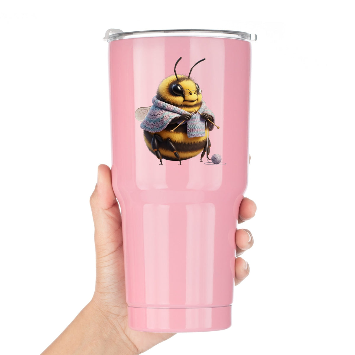 Bee Knitting In Shawl UV DTF sticker applied to a pink tumbler held against a white background