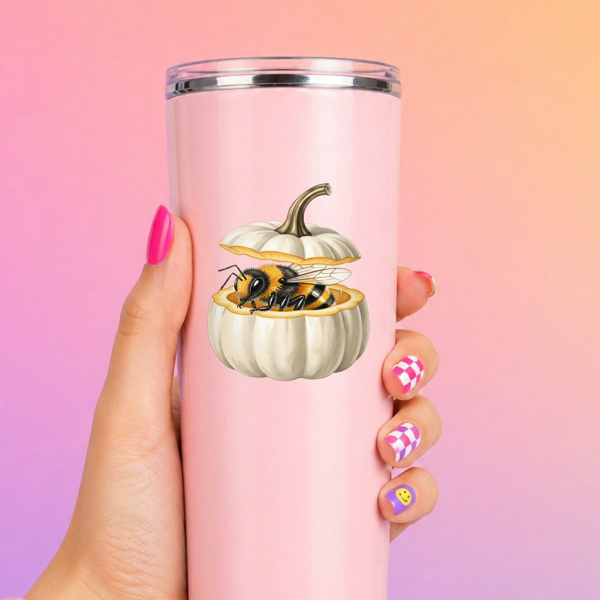 Sleepy Bee Inside White Pumpkin UV DTF sticker applied to a tall pink tumbler on a pink and orange background