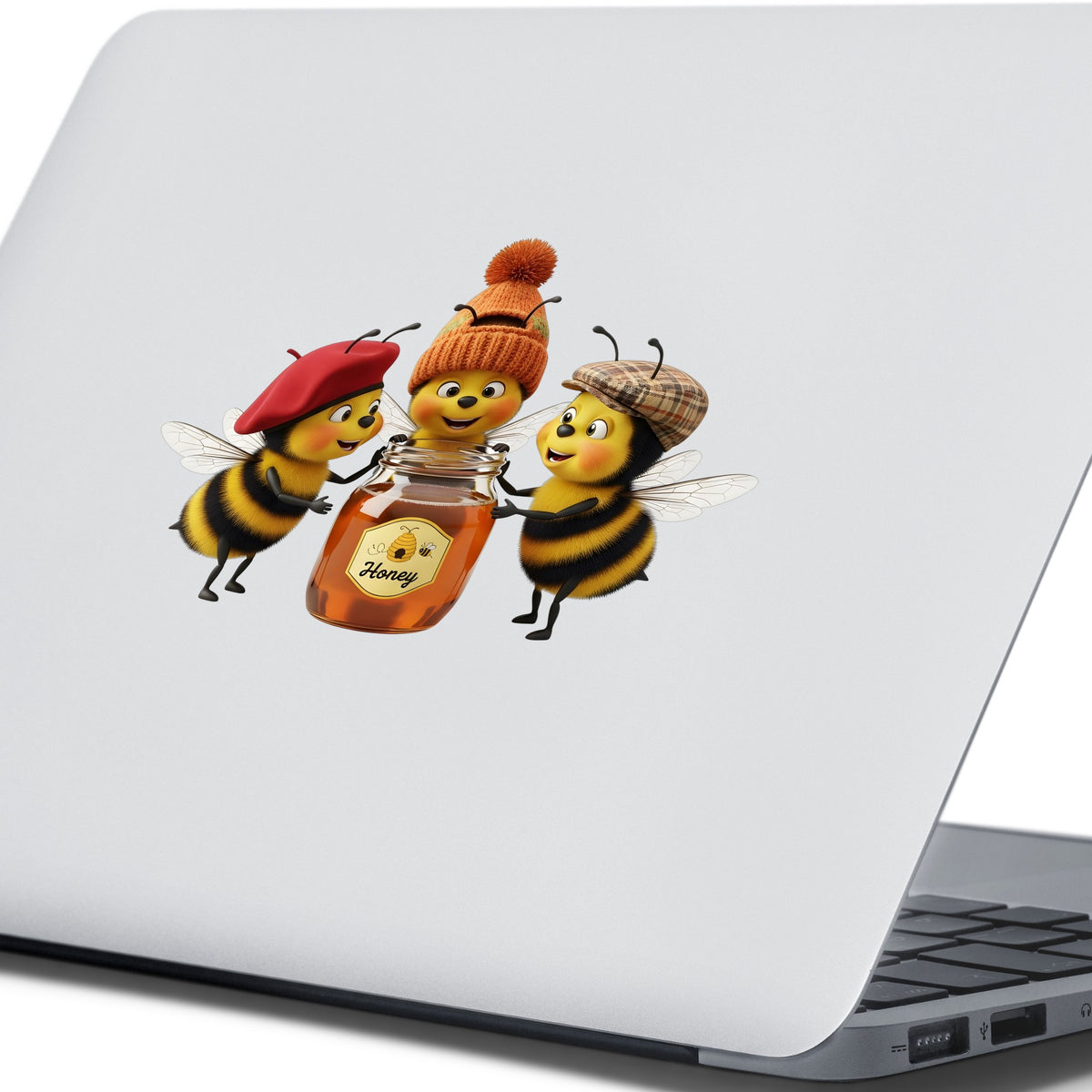 Three Bees With Honey Jar UV DTF sticker applied to the lid of a silver laptop