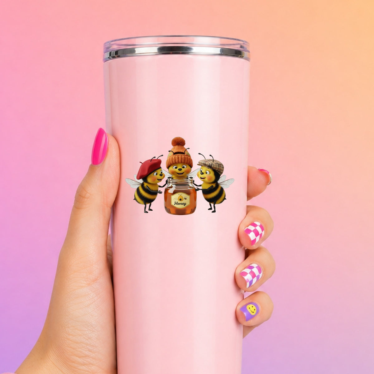 Three Bees With Honey Jar UV DTF sticker applied to a tall pink tumbler on a pink and orange background