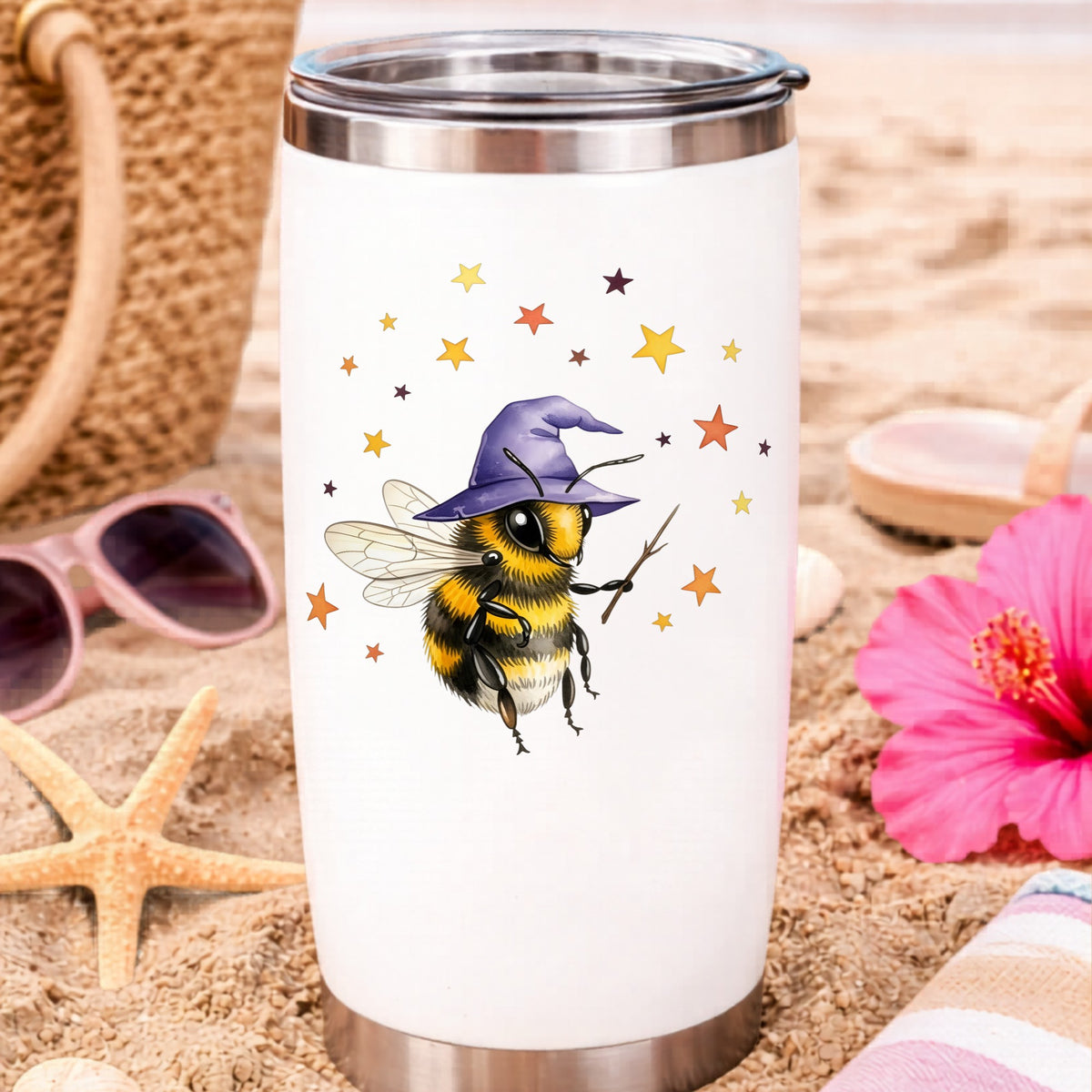 Bee Wizard With Stars UV DTF sticker applied to a white travel tumbler on beach sand