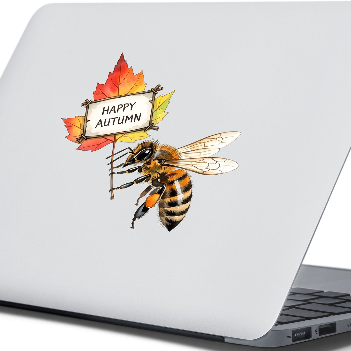 Honeybee Holding Happy Autumn Sign UV DTF sticker applied to the lid of a silver laptop