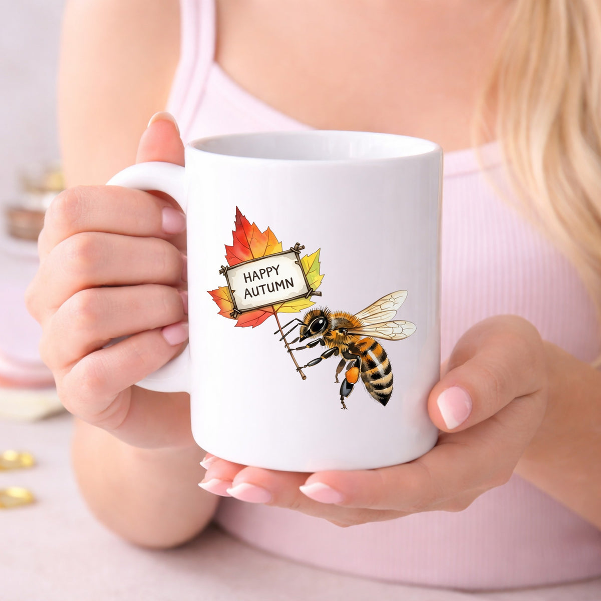 Honeybee Holding Happy Autumn Sign UV DTF sticker applied to a white coffee mug held in both hands