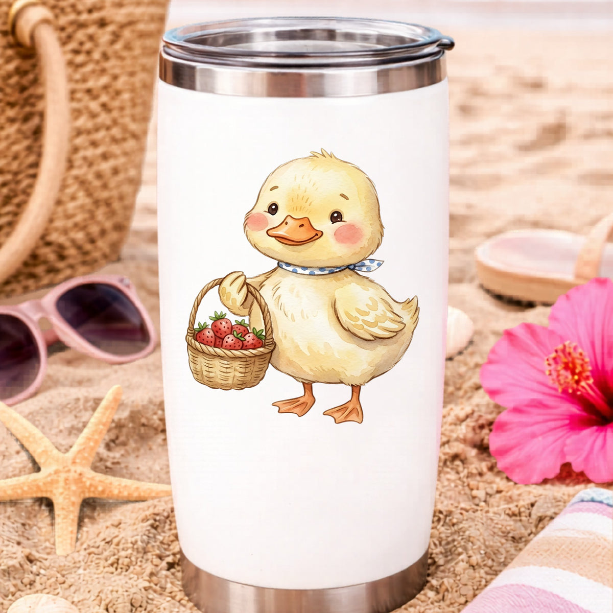 Duckling With Strawberry Basket UV DTF sticker applied to a white travel tumbler on beach sand