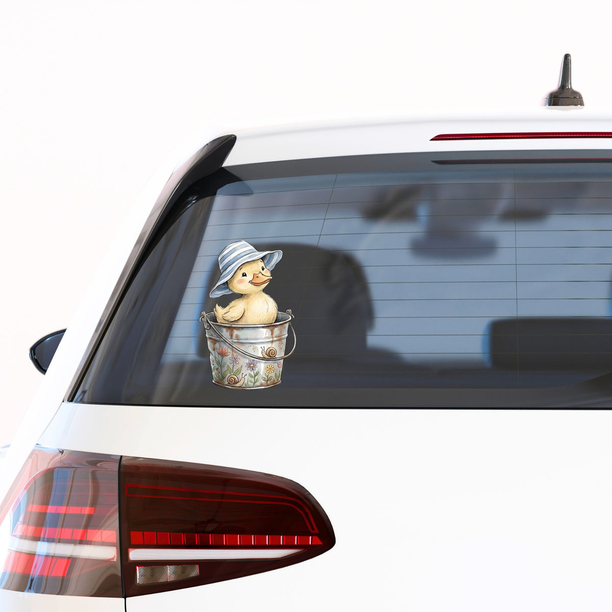 Duckling In Sun Hat In Bucket UV DTF sticker applied to the rear window of a white car