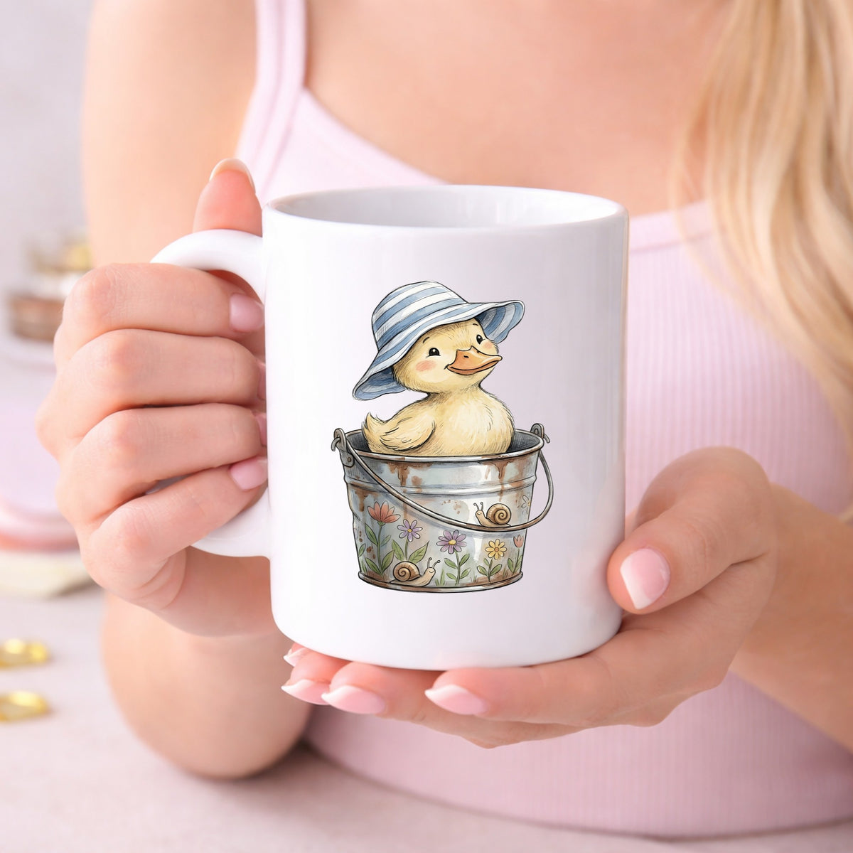 Duckling In Sun Hat In Bucket UV DTF sticker applied to a white coffee mug held in both hands
