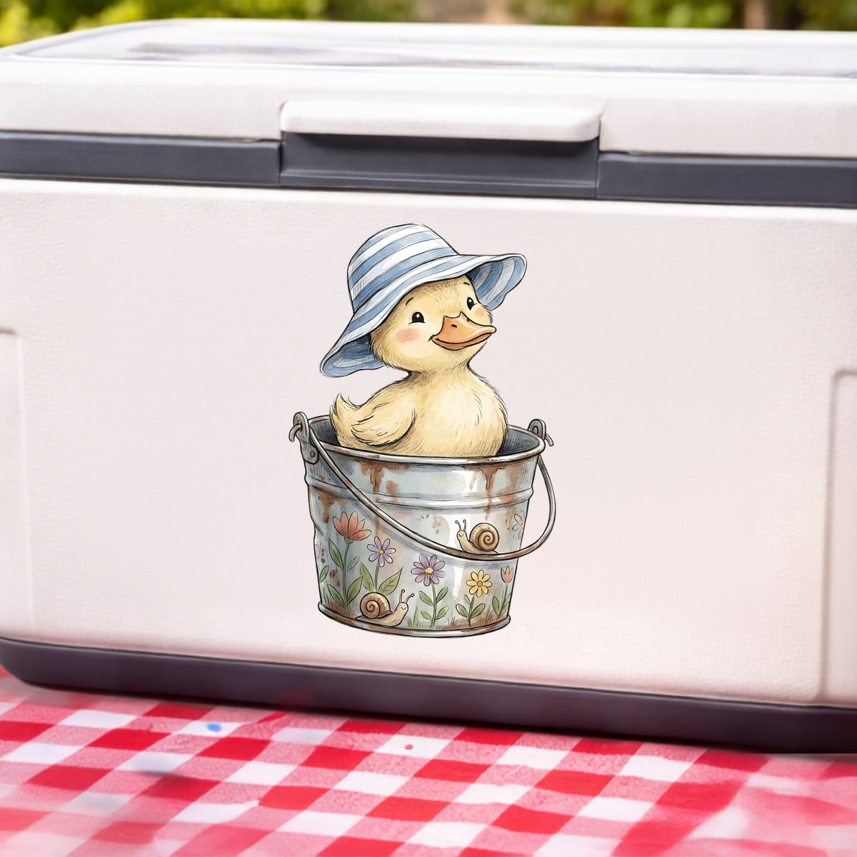 Duckling In Sun Hat In Bucket UV DTF sticker applied to a white cooler on a red gingham cloth