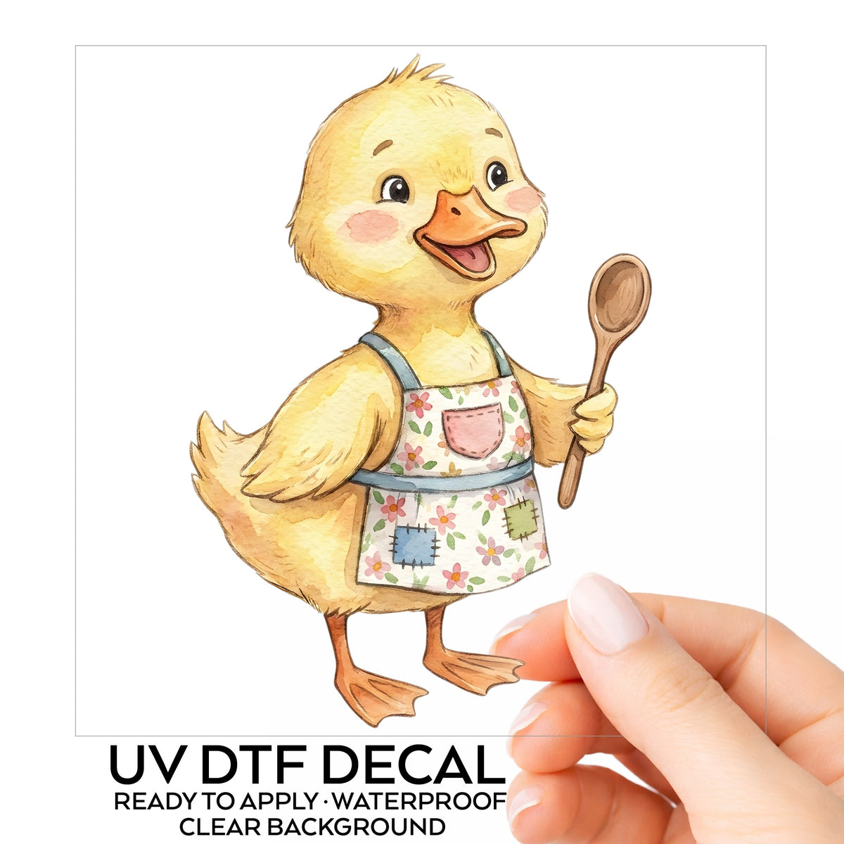 Duckling In Apron With Wooden Spoon UV DTF sticker on its backing card, held in hand