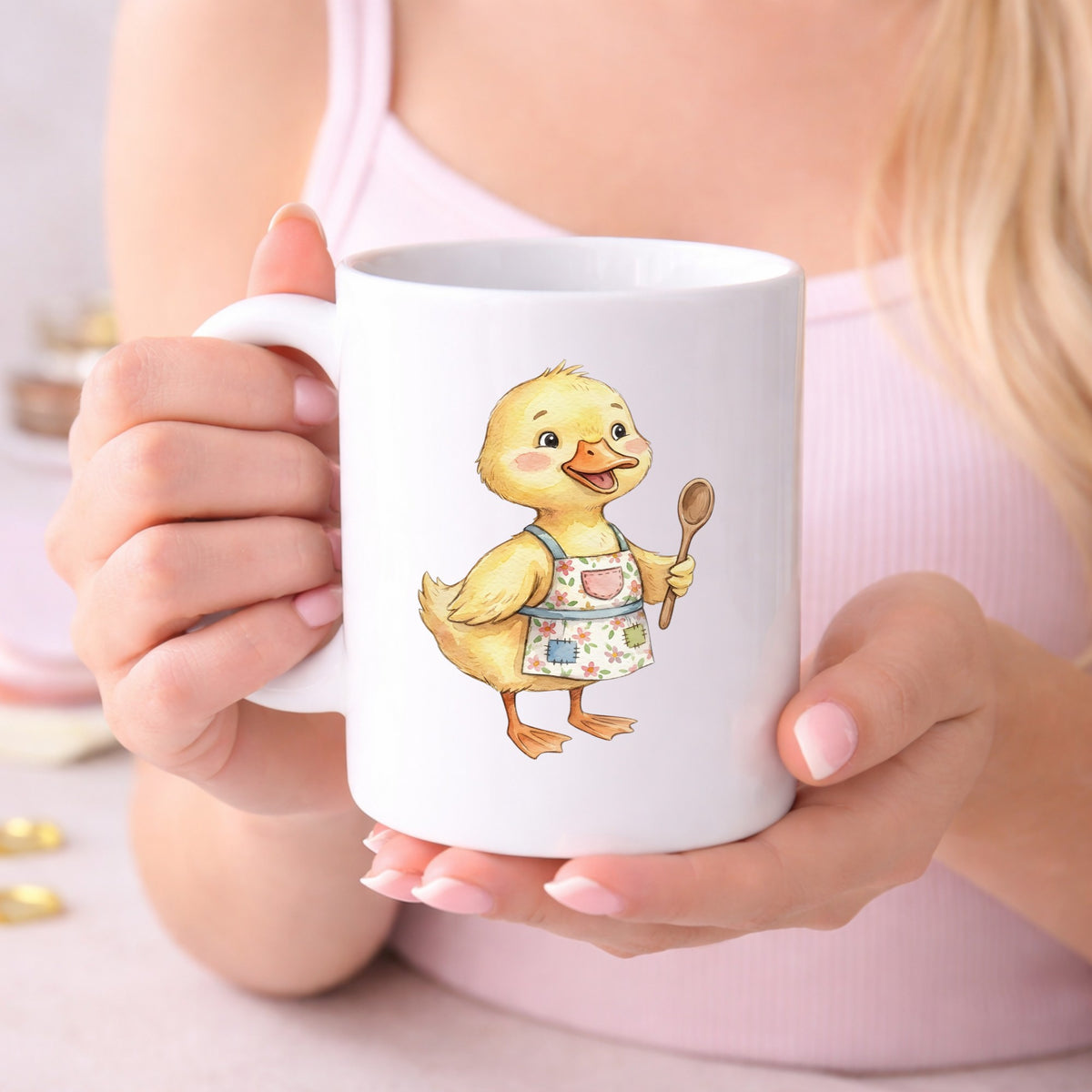 Duckling In Apron With Wooden Spoon UV DTF sticker applied to a white coffee mug held in both hands