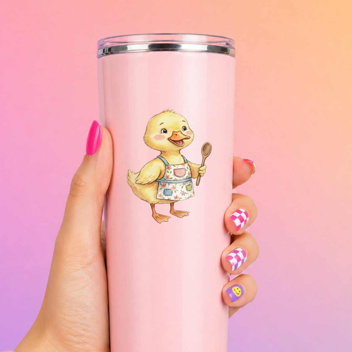 Duckling In Apron With Wooden Spoon UV DTF sticker applied to a tall pink tumbler on a pink and orange background