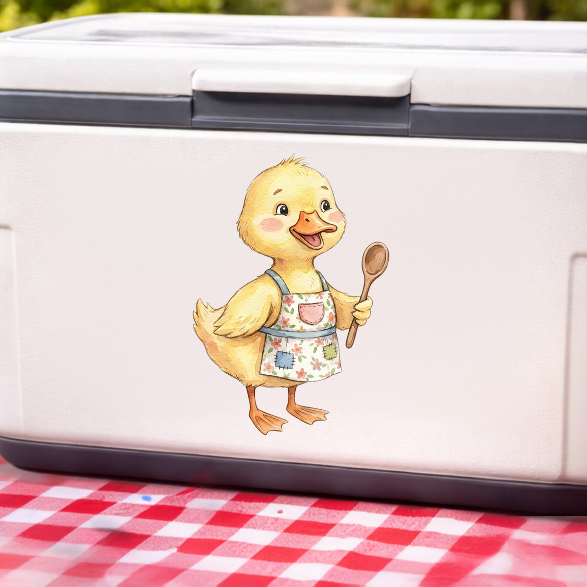 Duckling In Apron With Wooden Spoon UV DTF sticker applied to a white cooler on a red gingham cloth