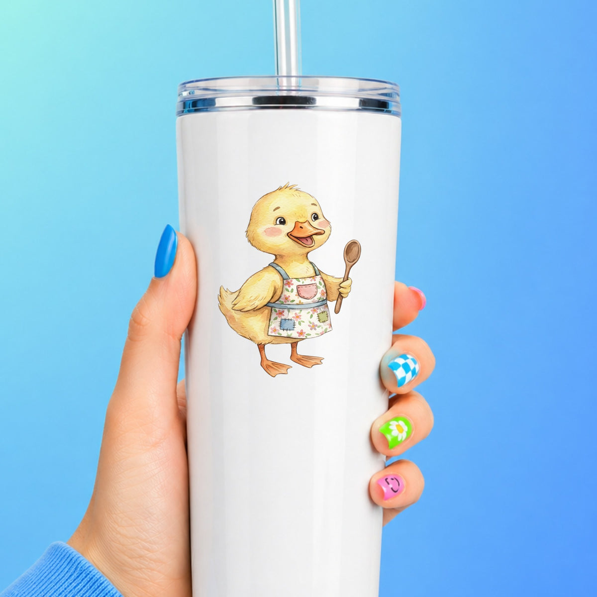 Duckling In Apron With Wooden Spoon UV DTF sticker applied to a white straw tumbler on a blue background