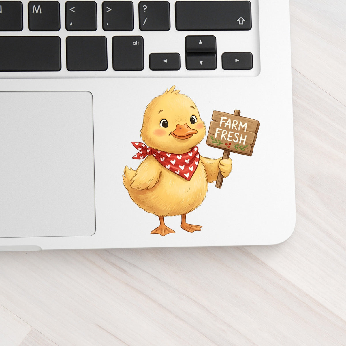 Duckling With Farm Fresh Sign UV DTF sticker applied to a silver laptop beside the keyboard