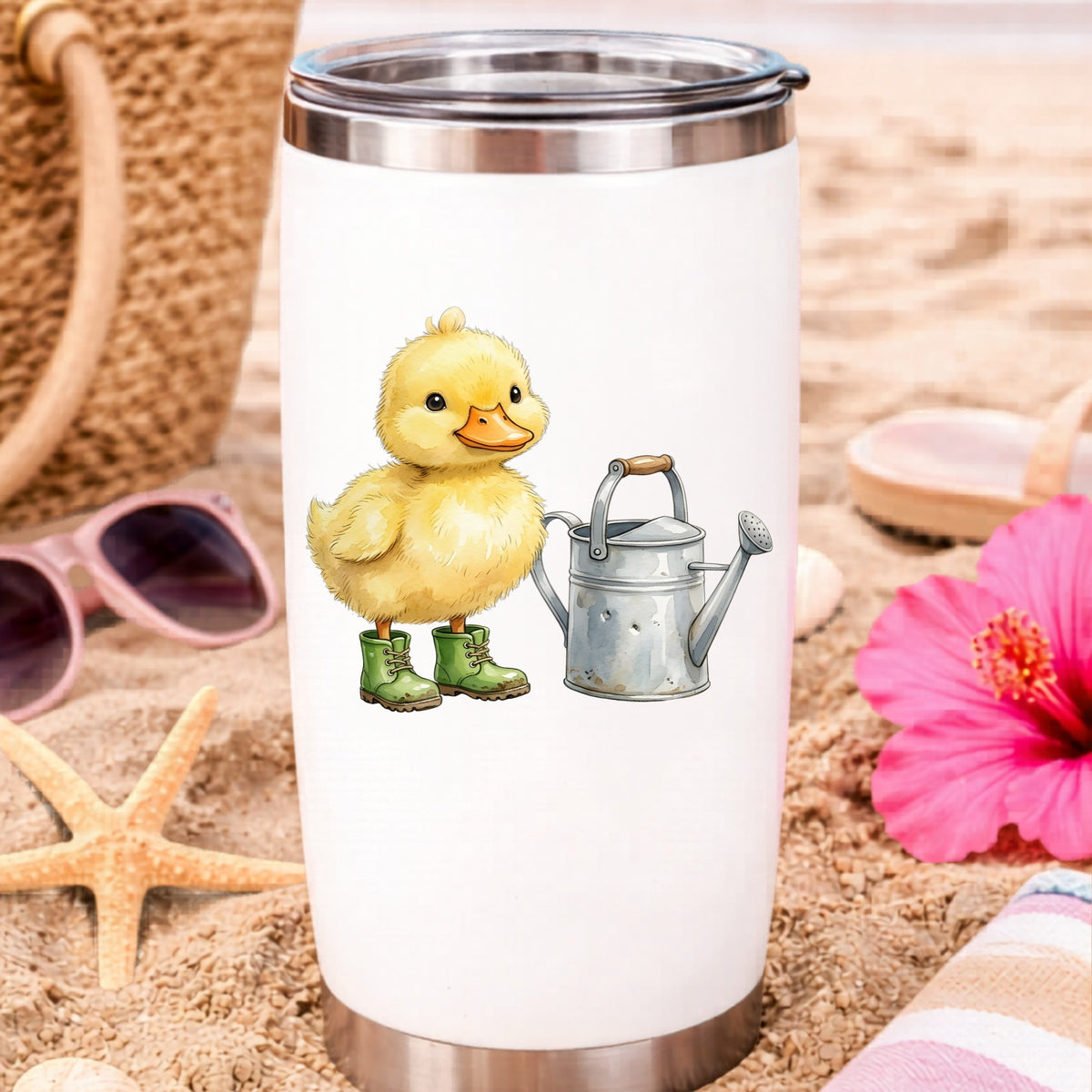 Duckling In Boots With Watering Can UV DTF sticker applied to a white travel tumbler on beach sand