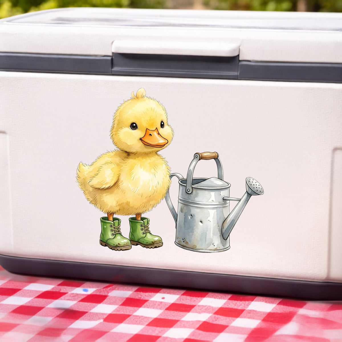Duckling In Boots With Watering Can UV DTF sticker applied to a white cooler on a red gingham cloth