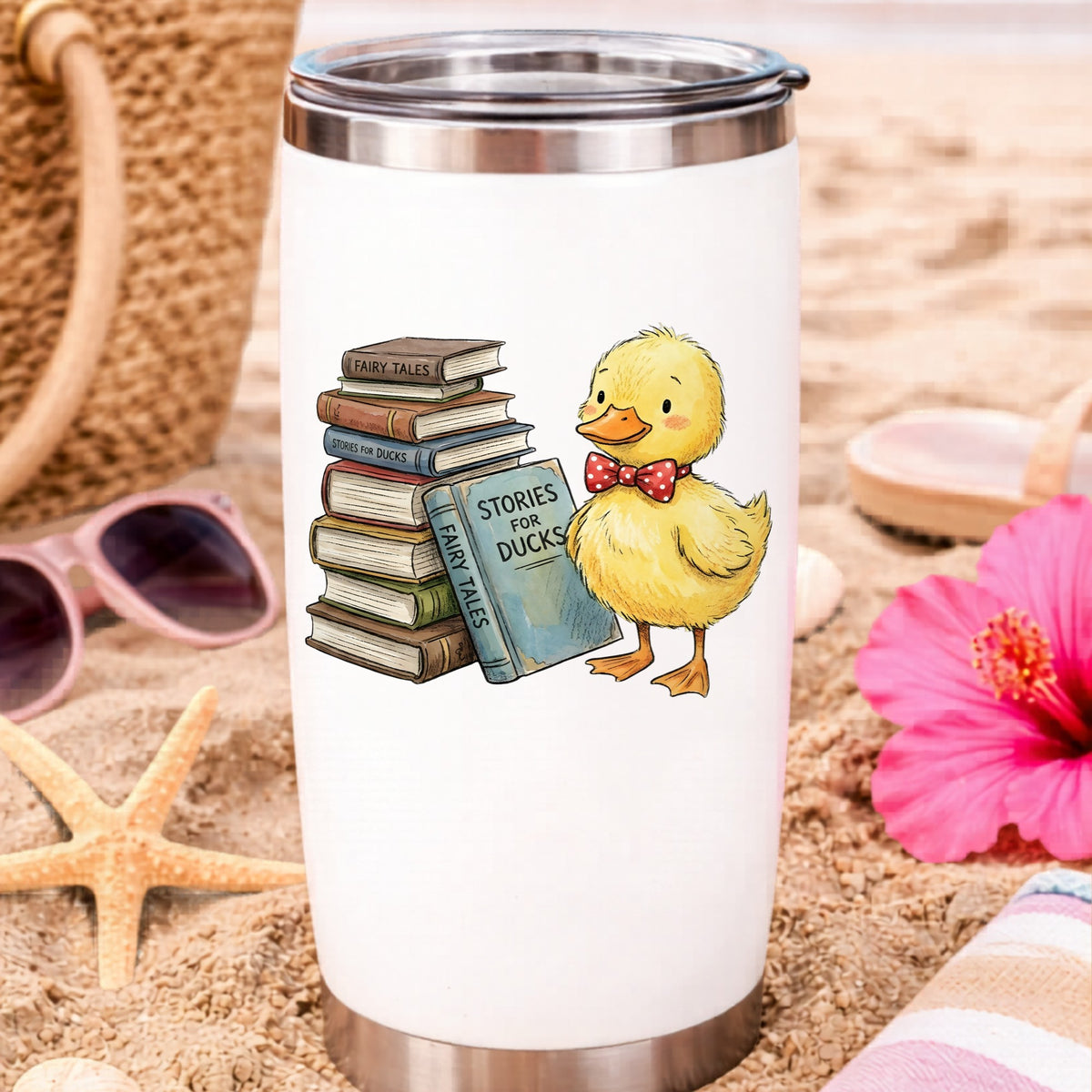Duckling With Stack Of Storybooks UV DTF sticker applied to a white travel tumbler on beach sand