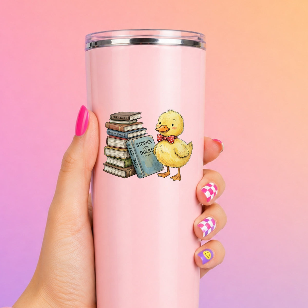 Duckling With Stack Of Storybooks UV DTF sticker applied to a tall pink tumbler on a pink and orange background