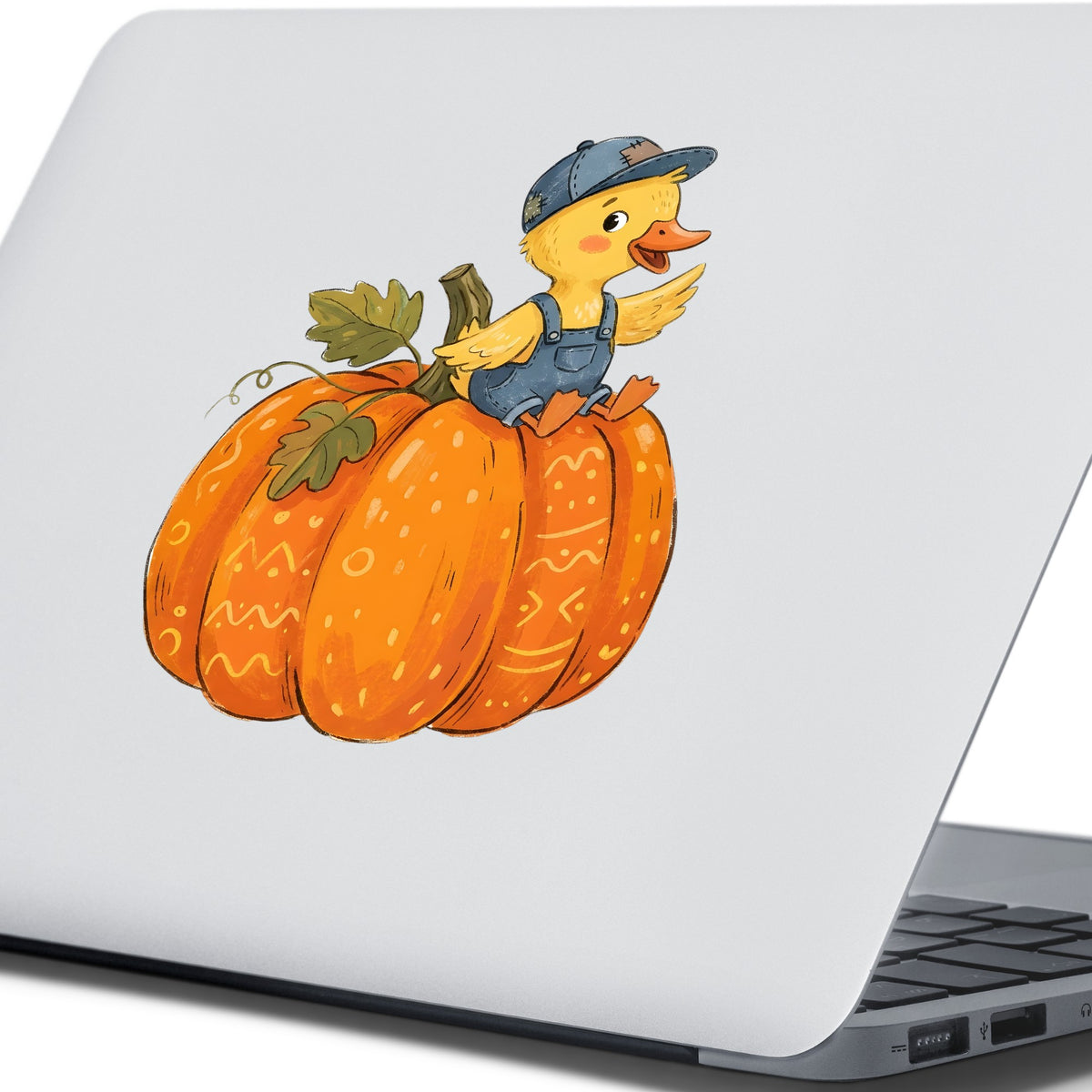 Duckling In Overalls On Pumpkin UV DTF sticker applied to the lid of a silver laptop