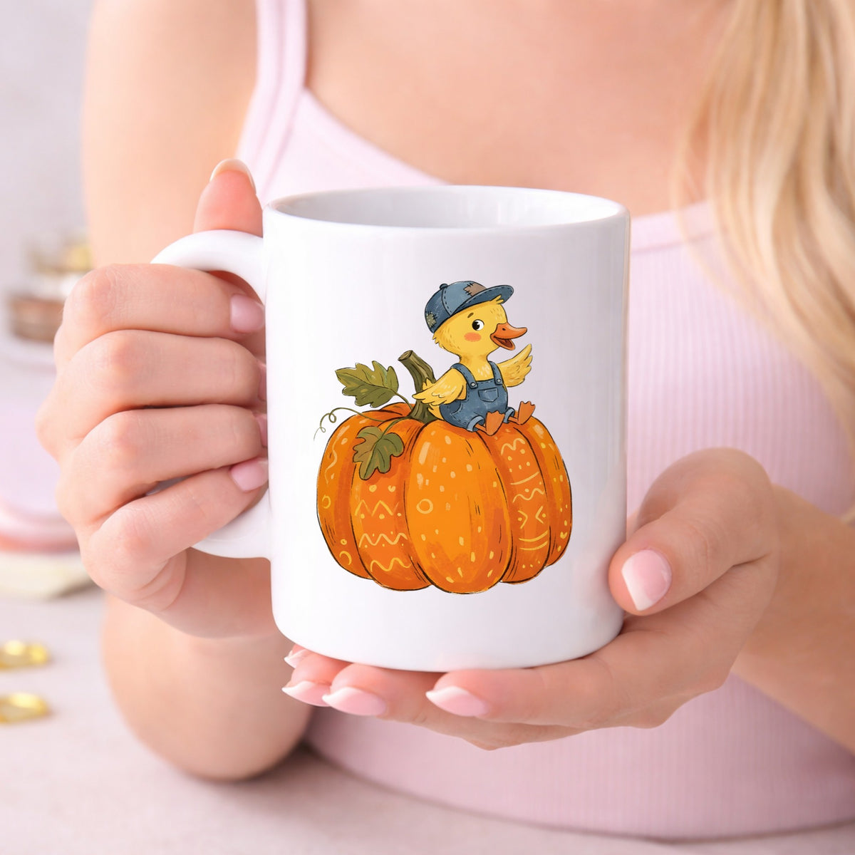 Duckling In Overalls On Pumpkin UV DTF sticker applied to a white coffee mug held in both hands