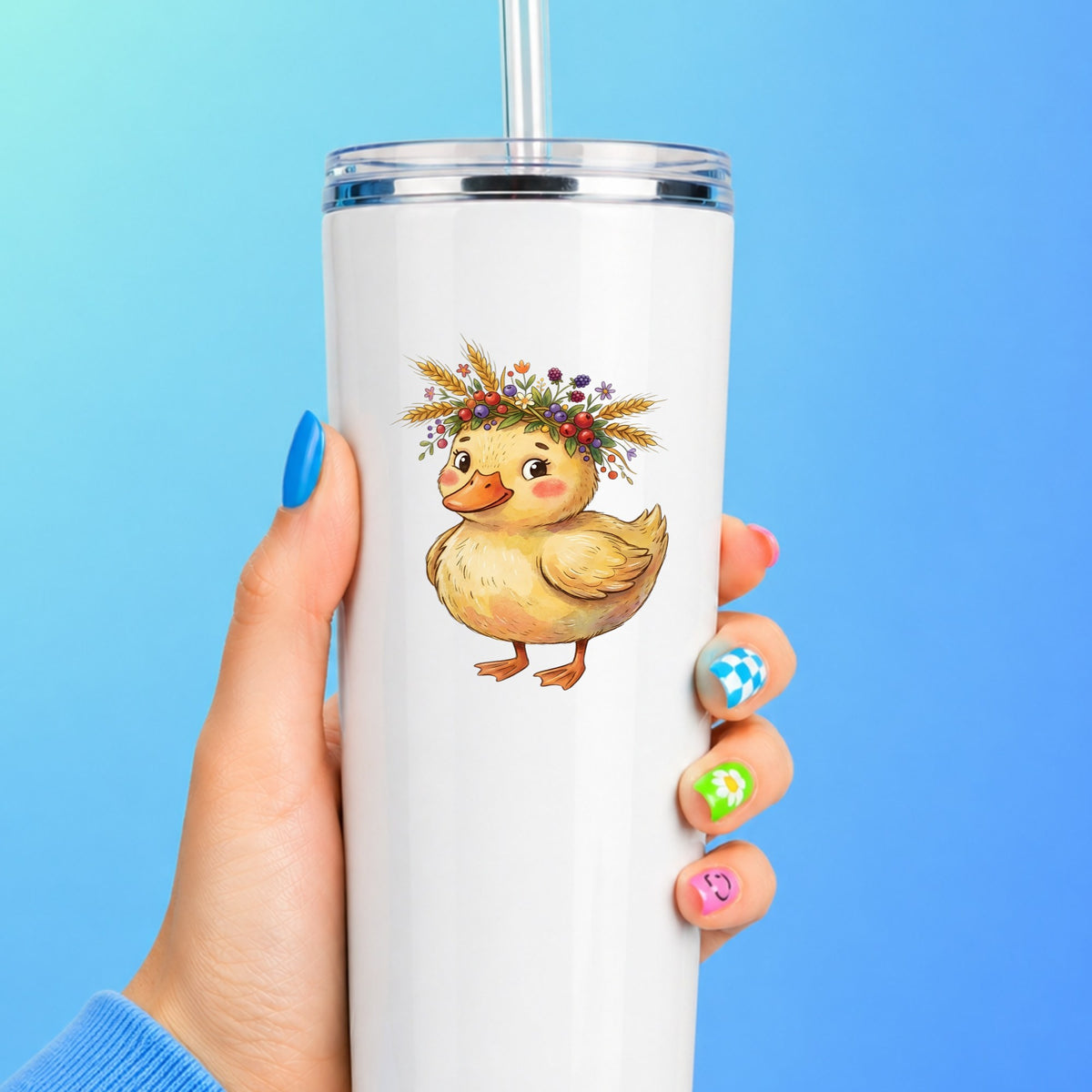 Duckling With Wheat And Berry Crown UV DTF sticker applied to a white straw tumbler on a blue background