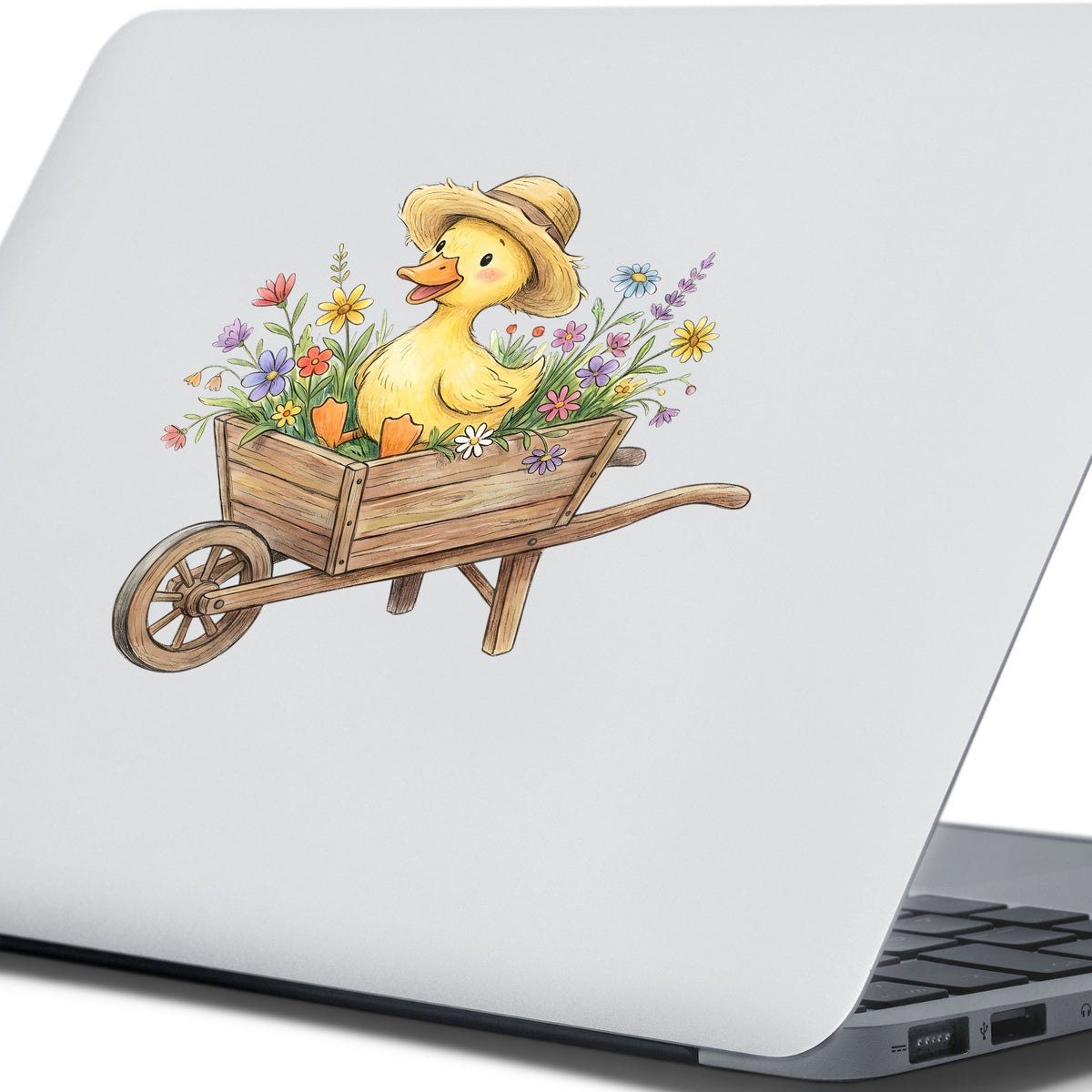 Duckling In Wheelbarrow Of Flowers UV DTF sticker applied to the lid of a silver laptop
