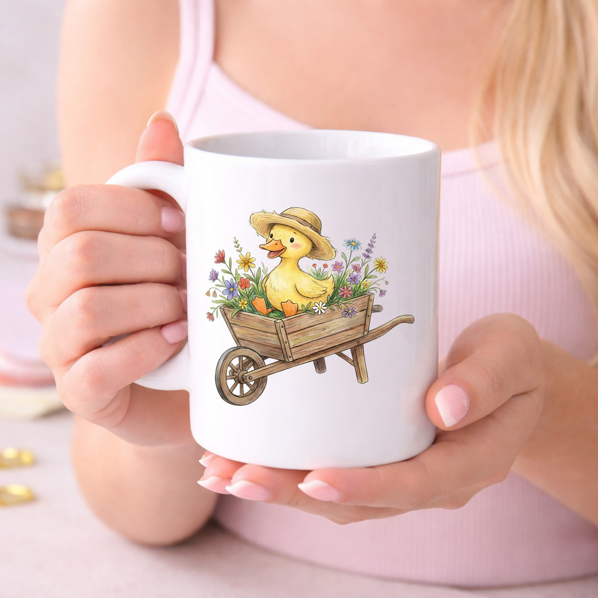 Duckling In Wheelbarrow Of Flowers UV DTF sticker applied to a white coffee mug held in both hands