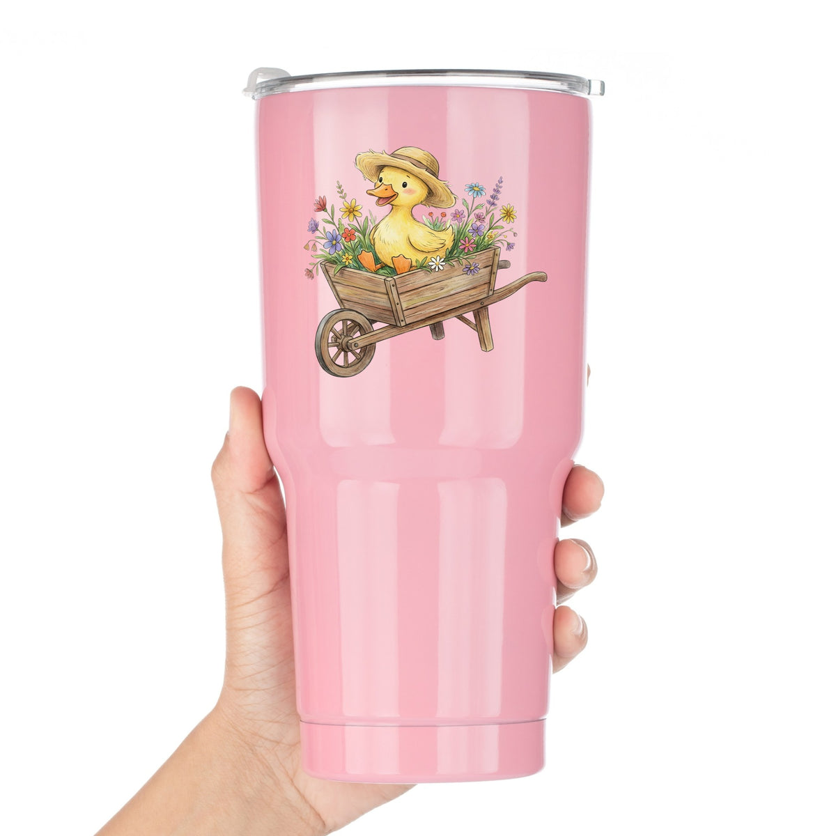 Duckling In Wheelbarrow Of Flowers UV DTF sticker applied to a pink tumbler held against a white background