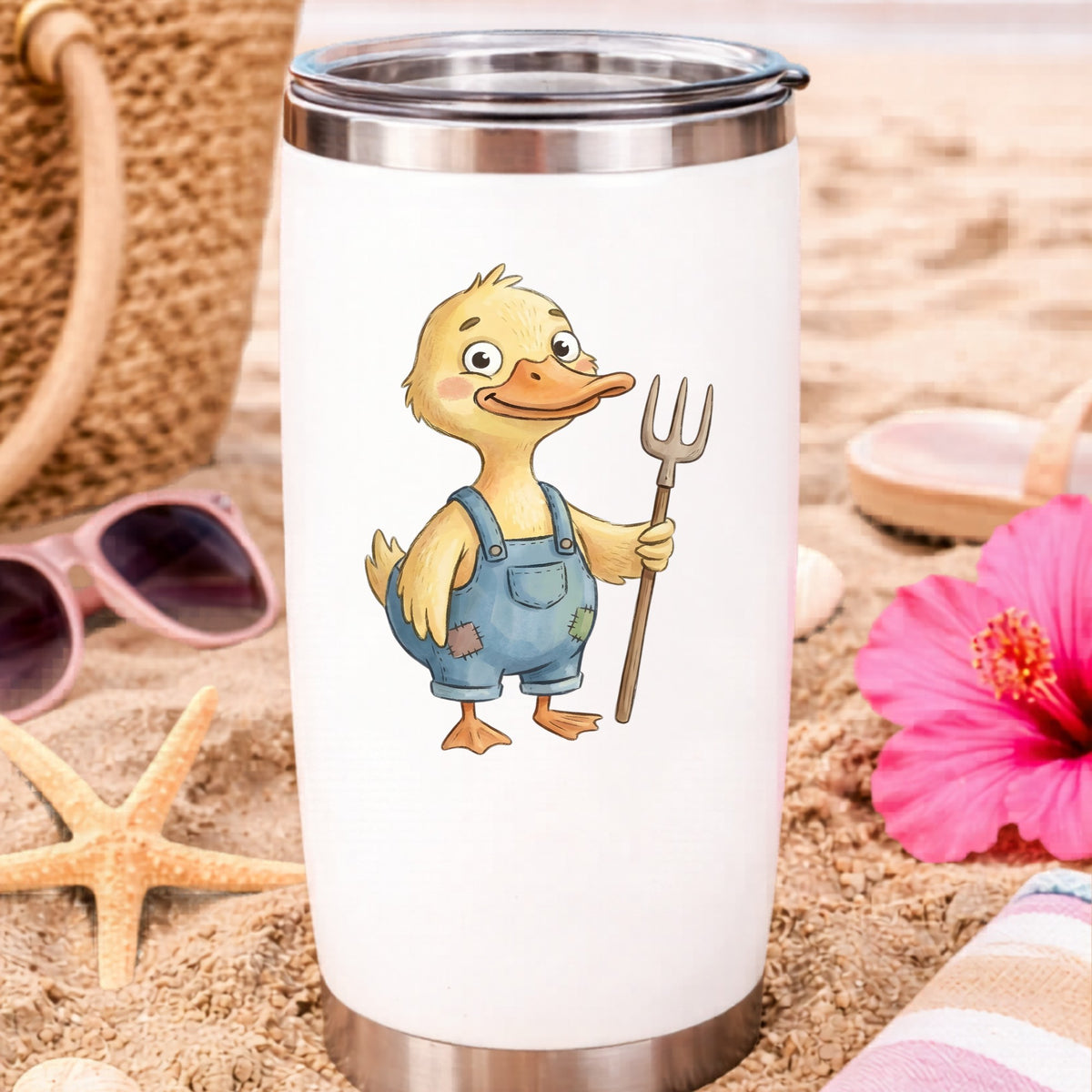 Duck In Overalls Holding Pitchfork UV DTF sticker applied to a white travel tumbler on beach sand