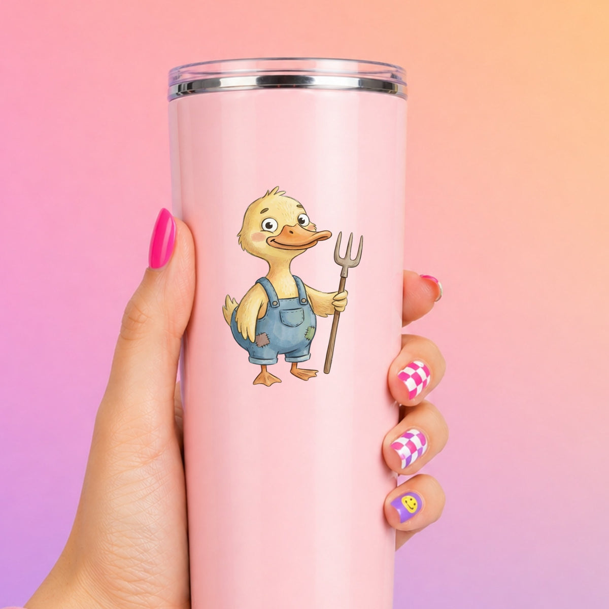 Duck In Overalls Holding Pitchfork UV DTF sticker applied to a tall pink tumbler on a pink and orange background