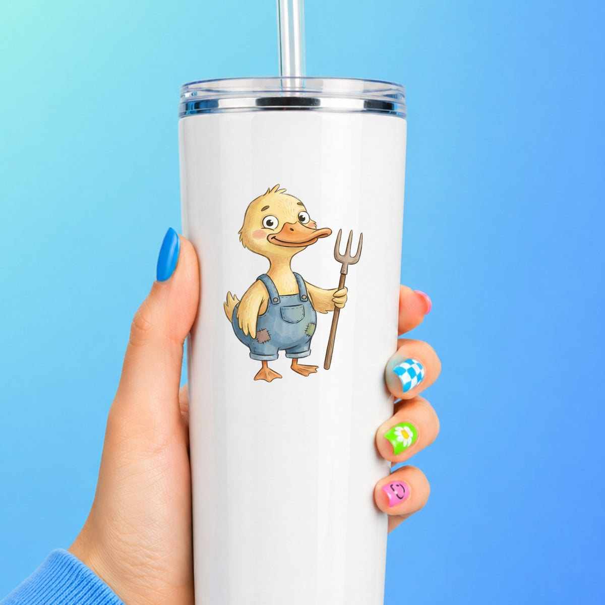 Duck In Overalls Holding Pitchfork UV DTF sticker applied to a white straw tumbler on a blue background