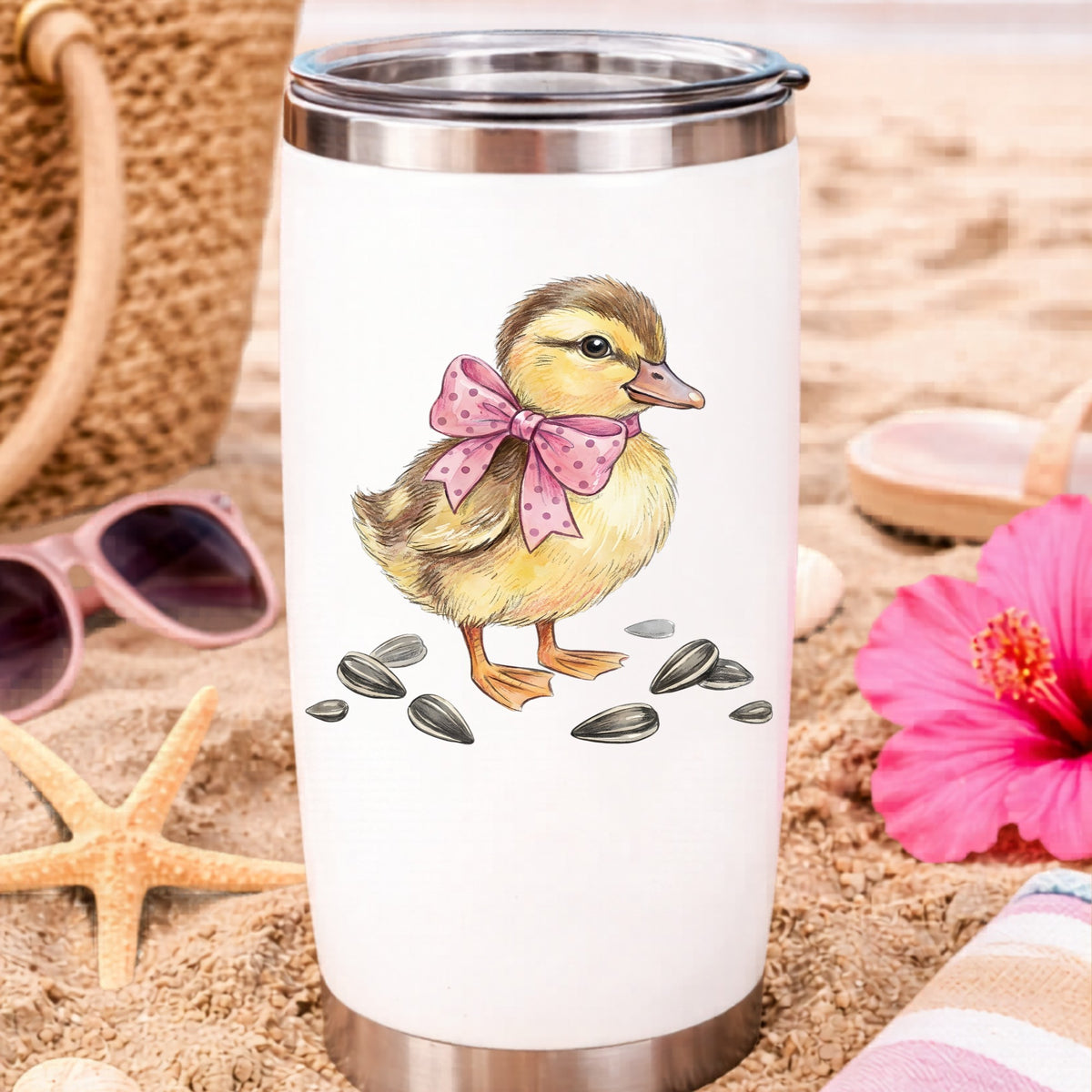 Brown Duckling With Pink Bow UV DTF sticker applied to a white travel tumbler on beach sand