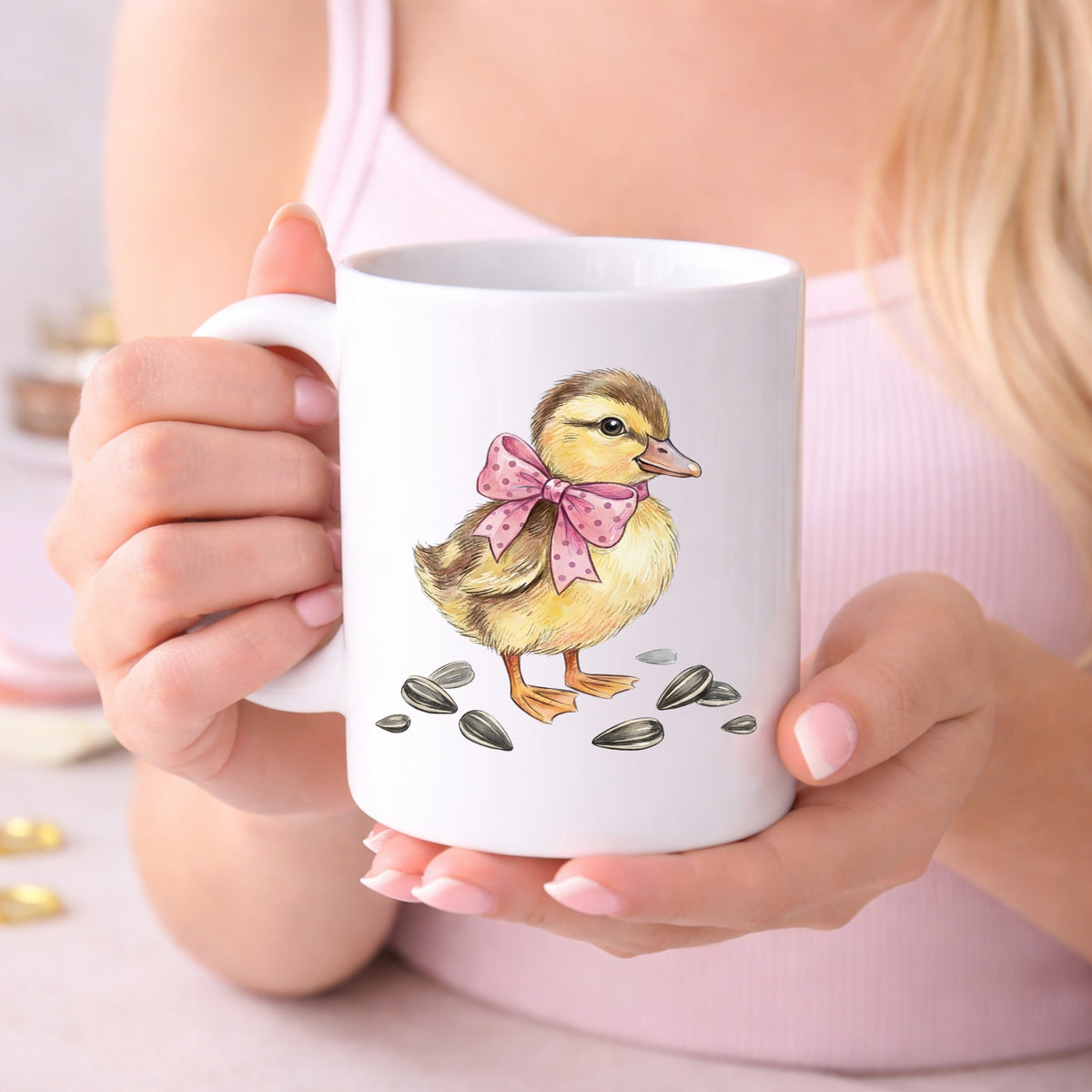 Brown Duckling With Pink Bow UV DTF sticker applied to a white coffee mug held in both hands