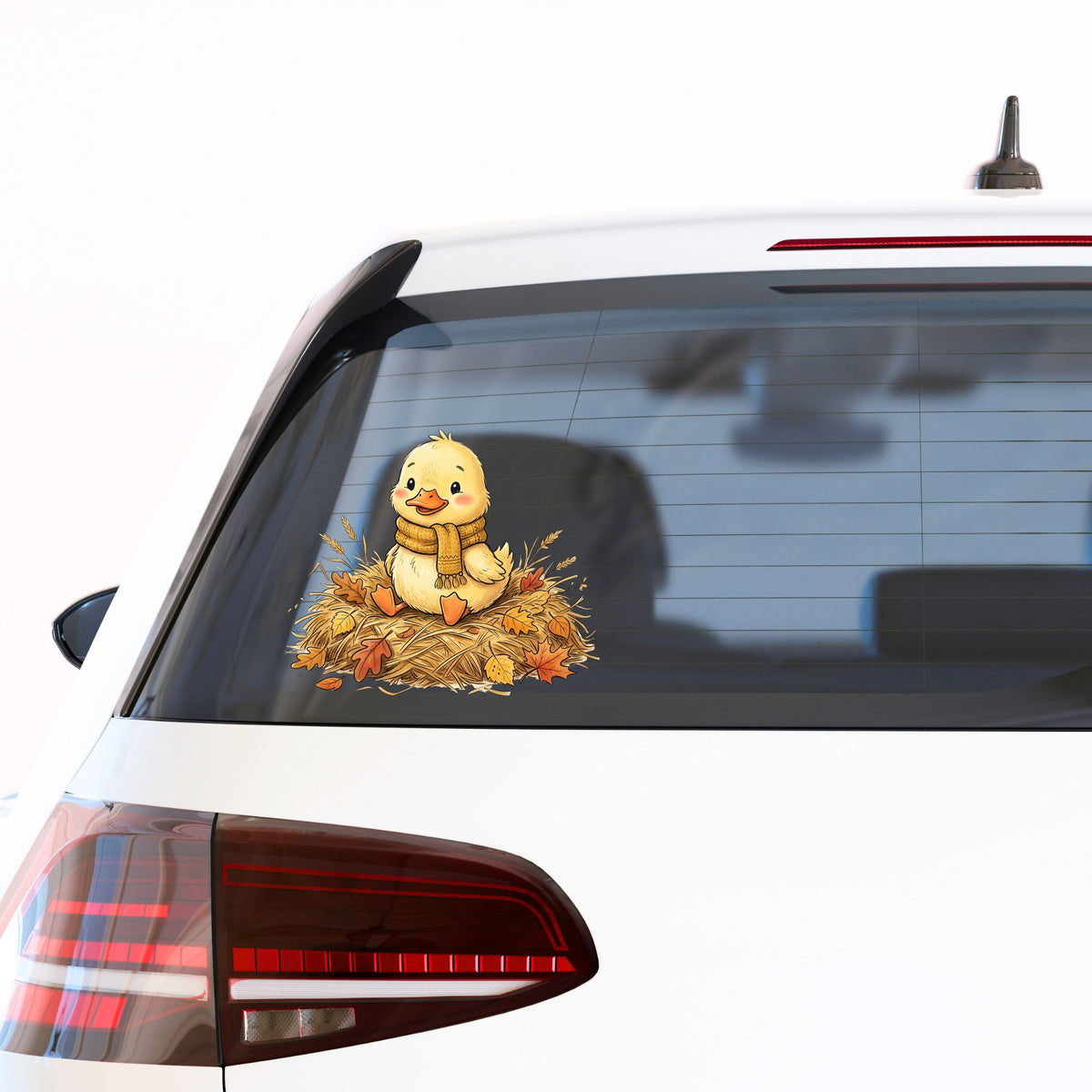 Duckling In Scarf On Hay With Autumn Leaves UV DTF sticker applied to the rear window of a white car