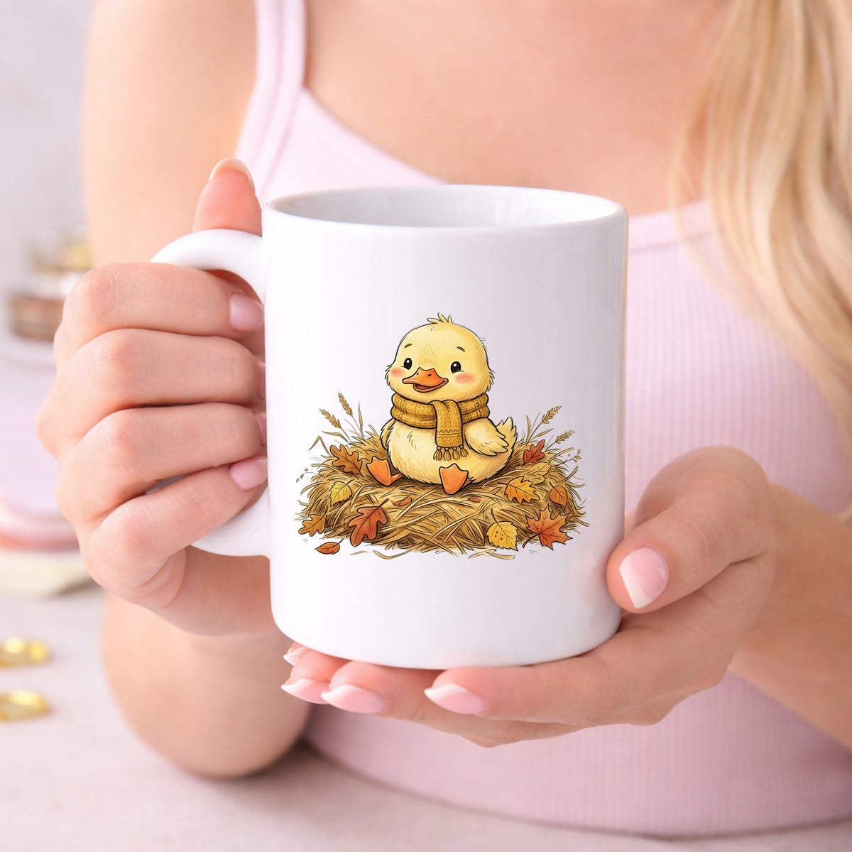 Duckling In Scarf On Hay With Autumn Leaves UV DTF sticker applied to a white coffee mug held in both hands