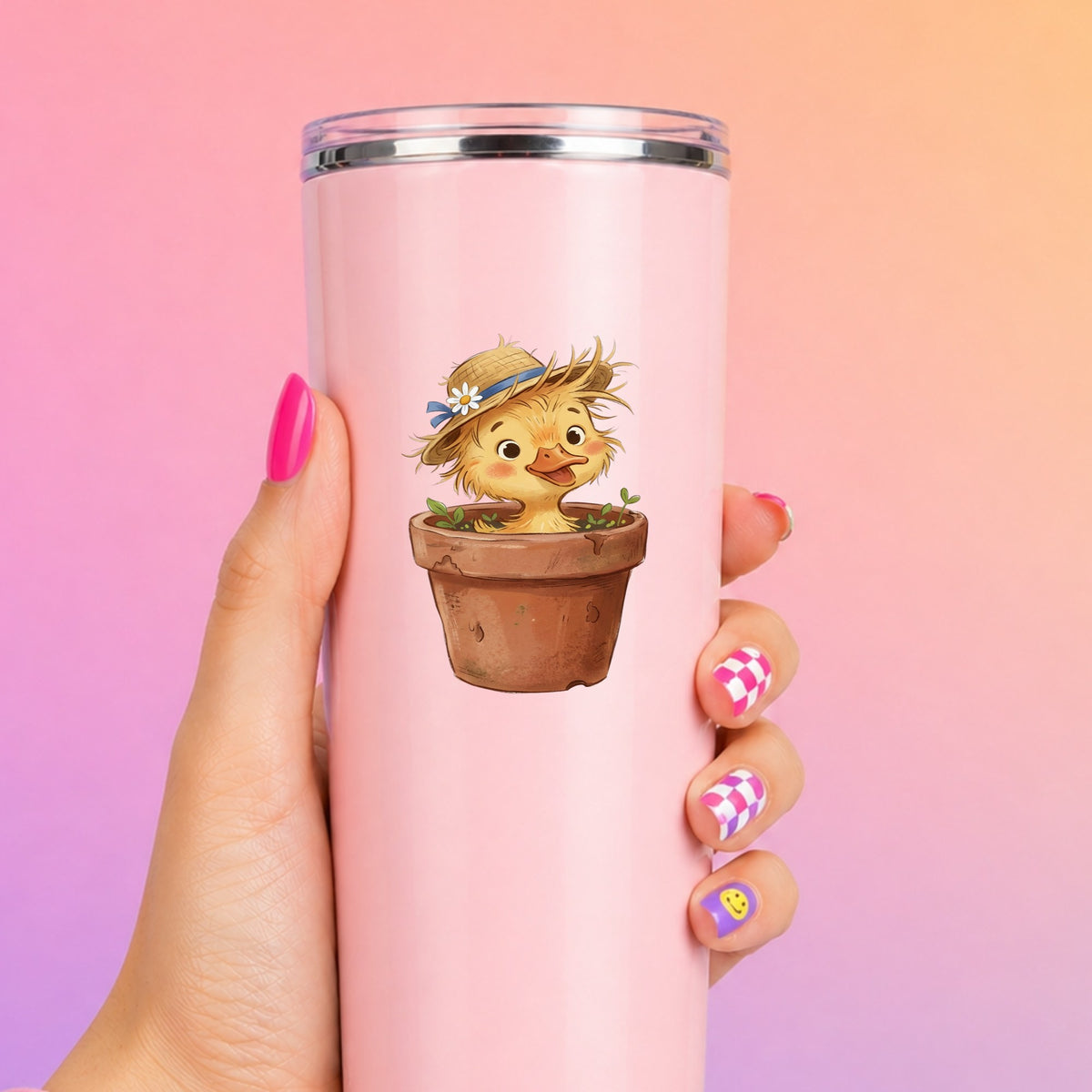 Fluffy Duckling In Flower Pot UV DTF sticker applied to a tall pink tumbler on a pink and orange background