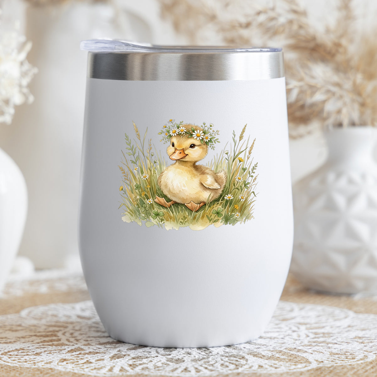 Duckling With Daisy Crown In Grass UV DTF sticker applied to a white stemless tumbler with a lid