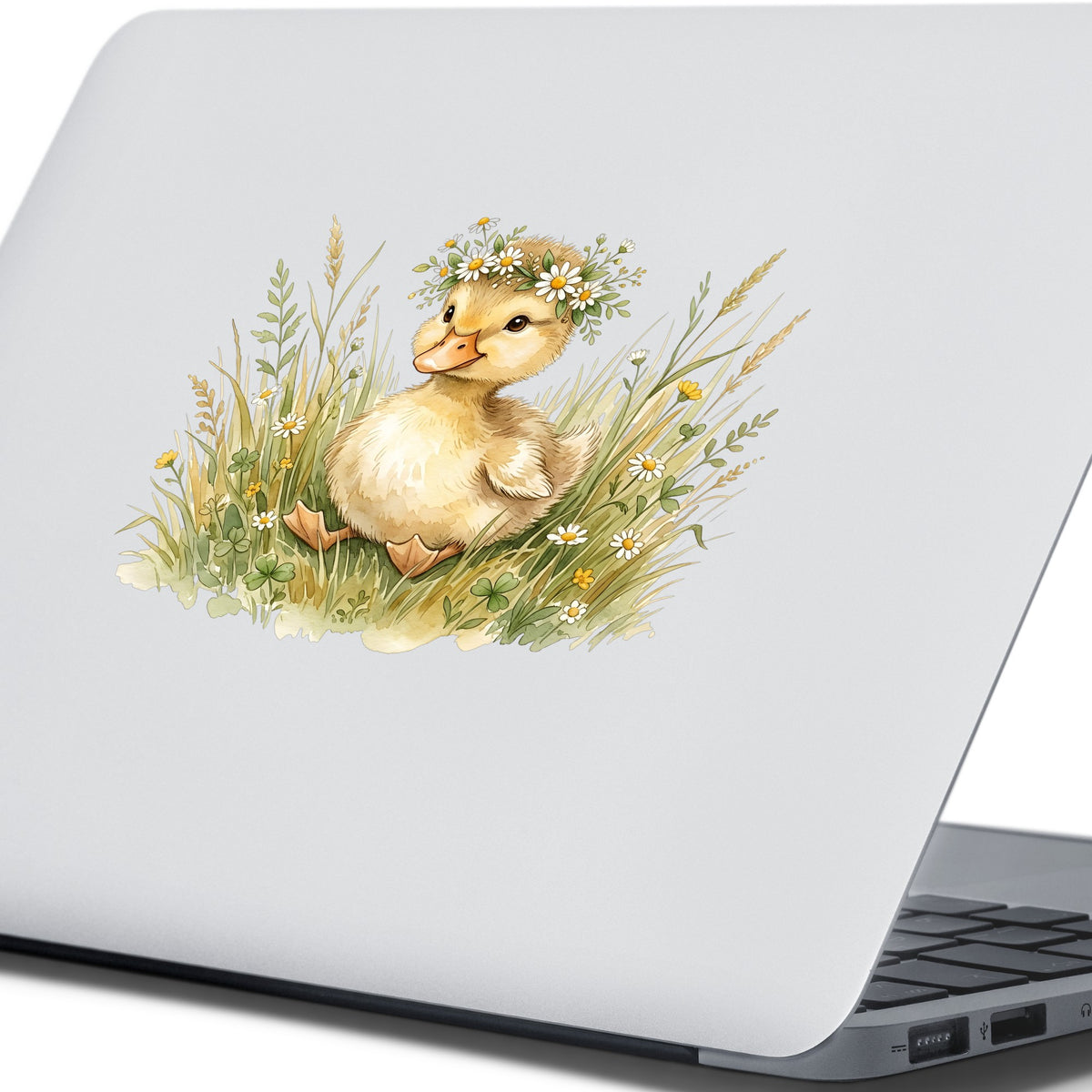 Duckling With Daisy Crown In Grass UV DTF sticker applied to the lid of a silver laptop