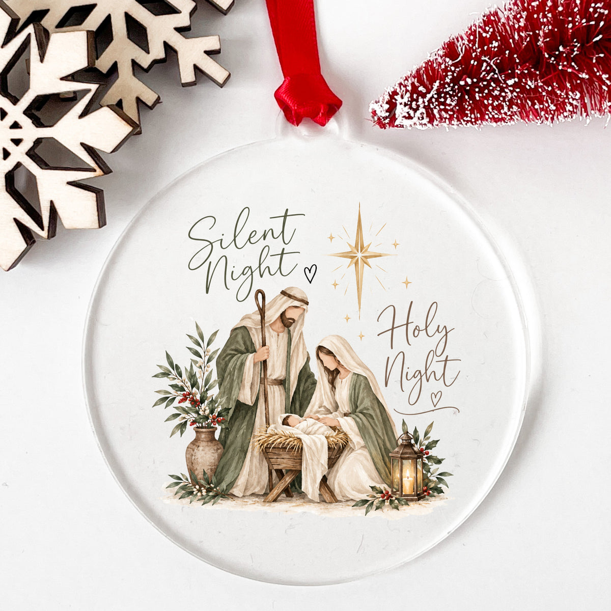Silent Night Nativity Scene UV DTF sticker applied to a clear round acrylic ornament with a red ribbon