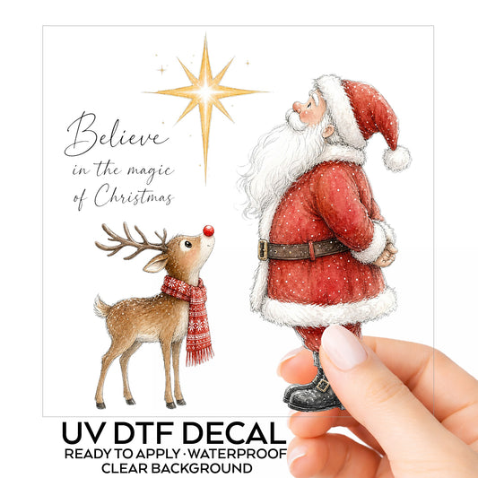 Believe Santa And Reindeer UV DTF sticker on its backing card, held in hand