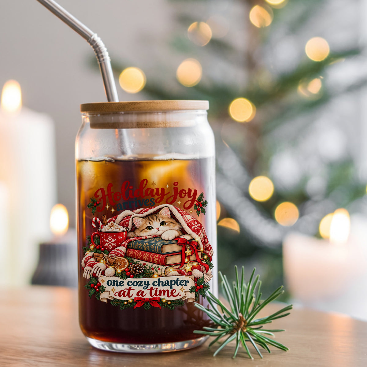 Cozy Kitten Under Plaid Blanket With Books UV DTF sticker applied to a glass can cup of iced coffee with a straw