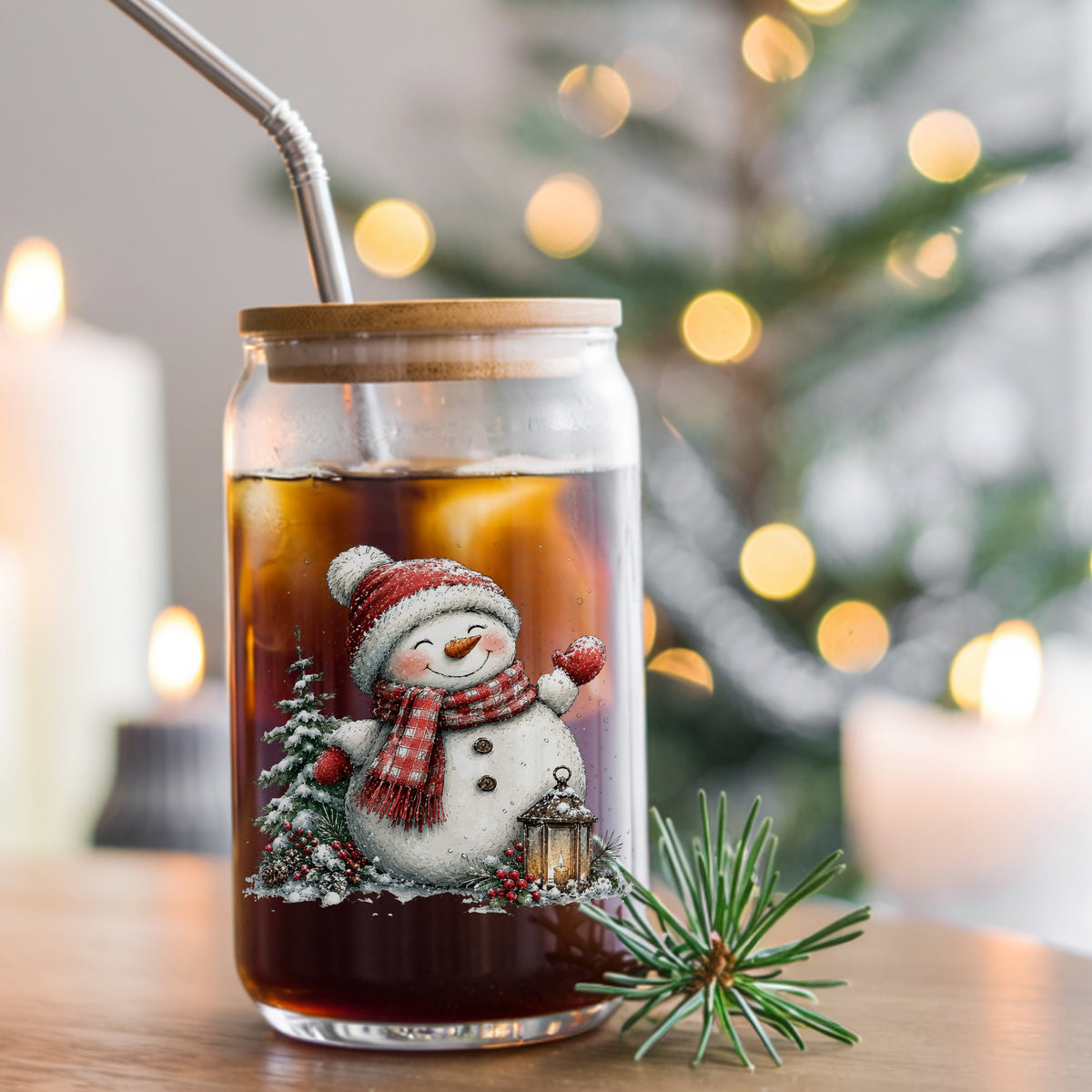 Waving Snowman By Snowy Pine Tree UV DTF sticker applied to a glass can cup of iced coffee with a straw