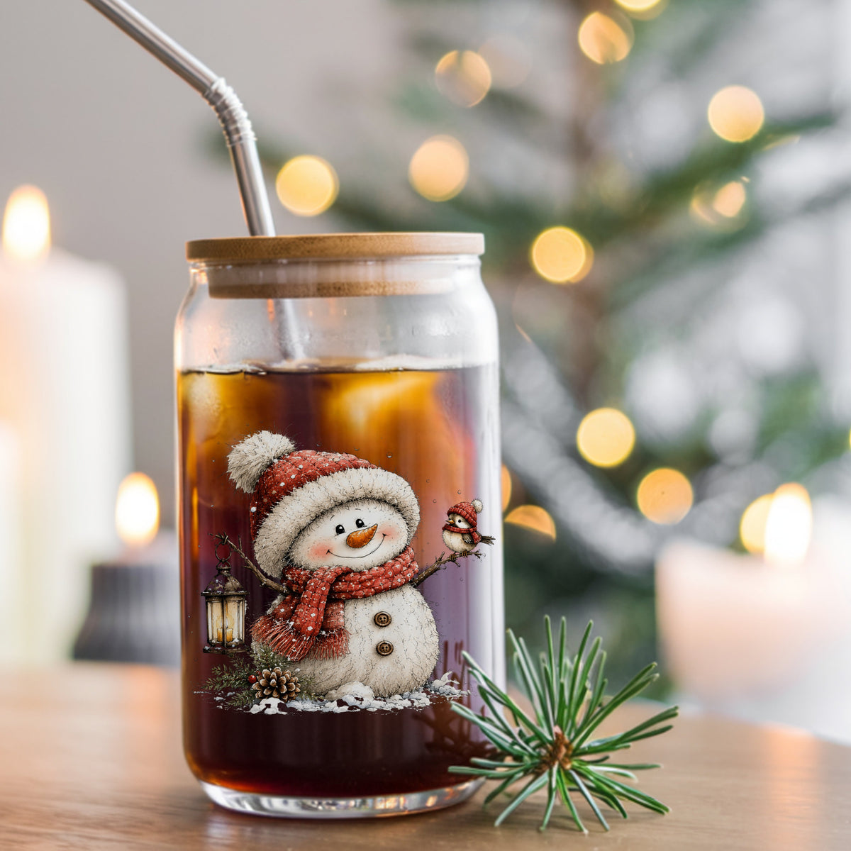 Snowman With Tiny Bird In Red Hat UV DTF sticker applied to a glass can cup of iced coffee with a straw