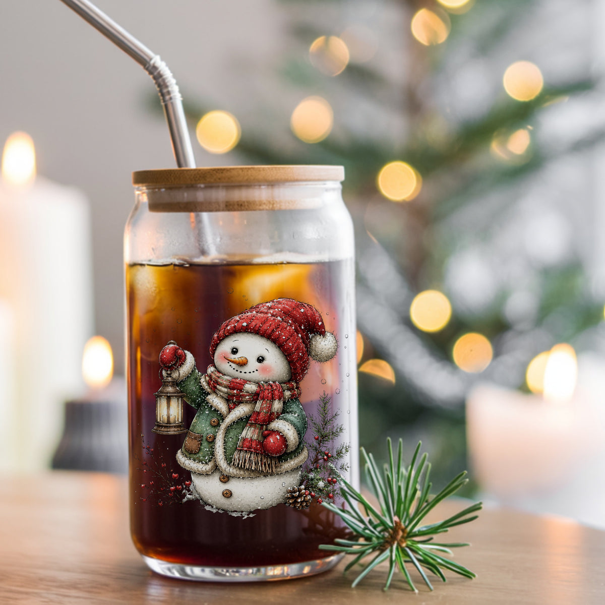 Green Coat Snowman Holding Lantern UV DTF sticker applied to a glass can cup of iced coffee with a straw