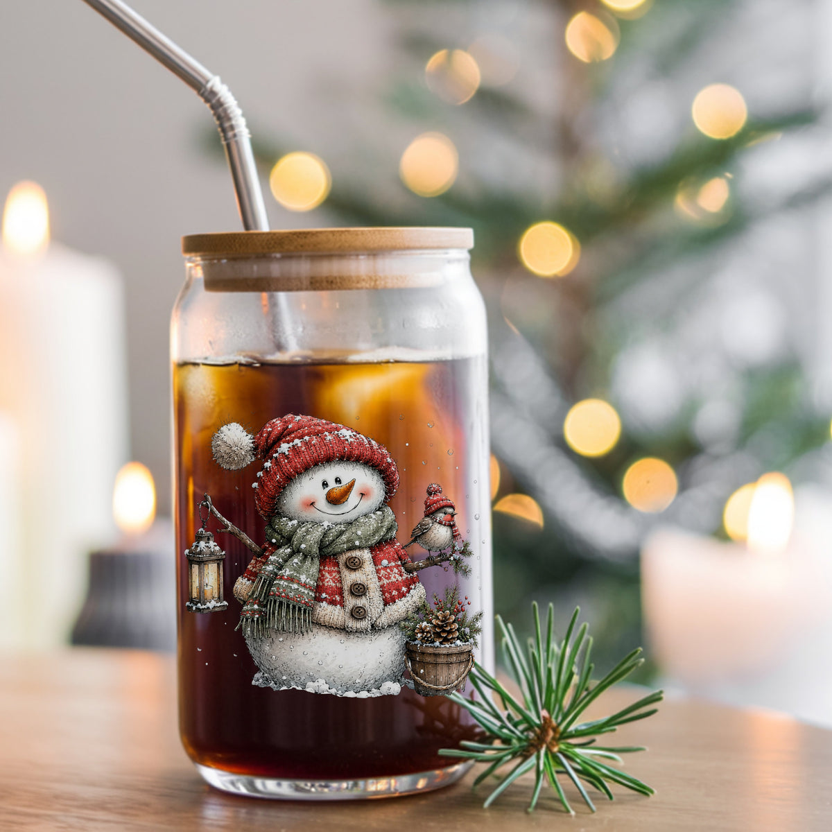 Fair Isle Sweater Snowman With Bird UV DTF sticker applied to a glass can cup of iced coffee with a straw