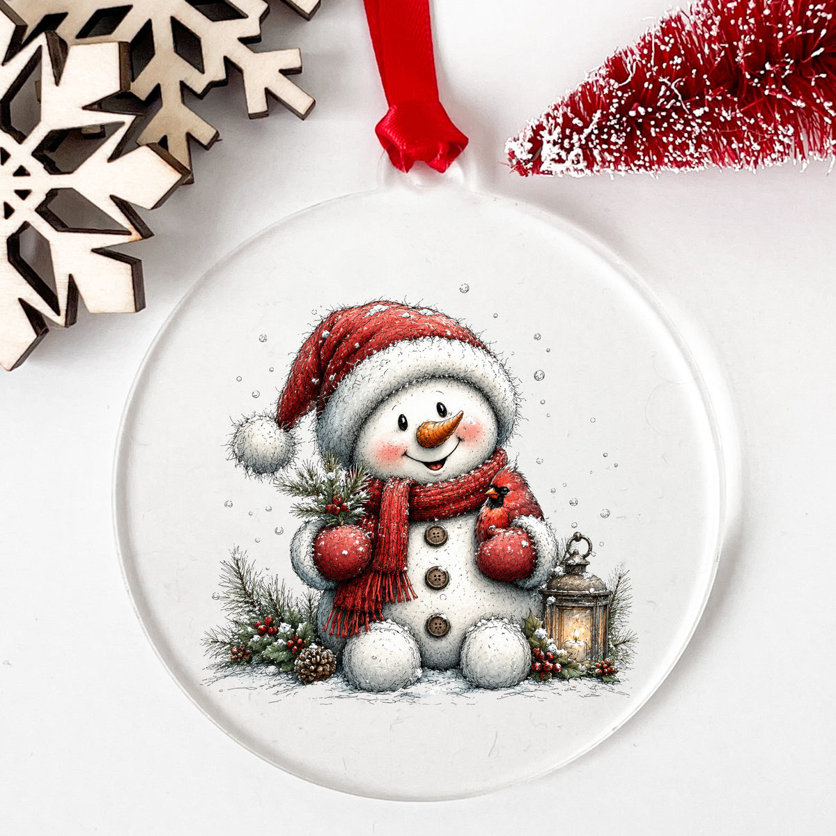 Snowman Holding Red Cardinal UV DTF sticker applied to a clear round acrylic ornament with a red ribbon